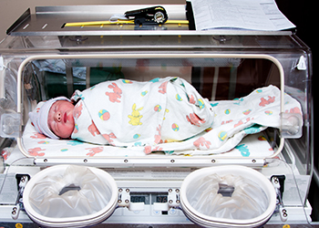 A premature infant in an incubator