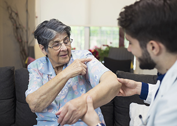 An older lady being examined by a nurse