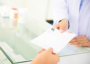 A doctor handing over a prescription