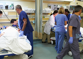 Patients being examined in a busy hospital room