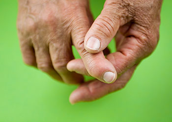 A close up of an older person massaging their fingers
