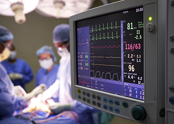 An patient undergoing surgery with a monitor in the foreground