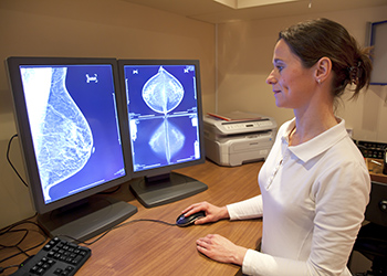 A technician looking at the results of a mammogram