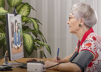 An older woman talks to her doctor online