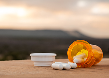 A bottle of prescription pills on a table outside