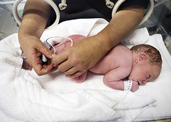 A midwife examining a newborn baby