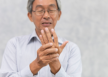 An older man with pain in the joints of his hands