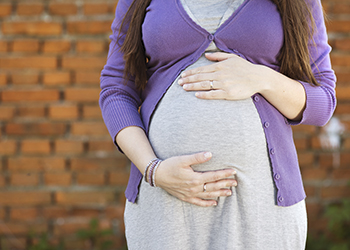 A pregnant woman holding her baby bump