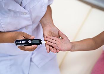 A doctor administers a diabetic blood sugar test to a child