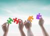 Children hold up multi coloured jigsaw pieces