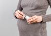 A pregnant women opens a bottle of pills