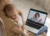 A young mother holds a baby and talks to a pediatrician online