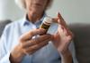 An older woman looking at the instructions on a bottle of pills