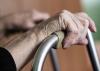 A older woman holding a walking frame