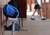 A backpack and schoolbooks with a girl in the background